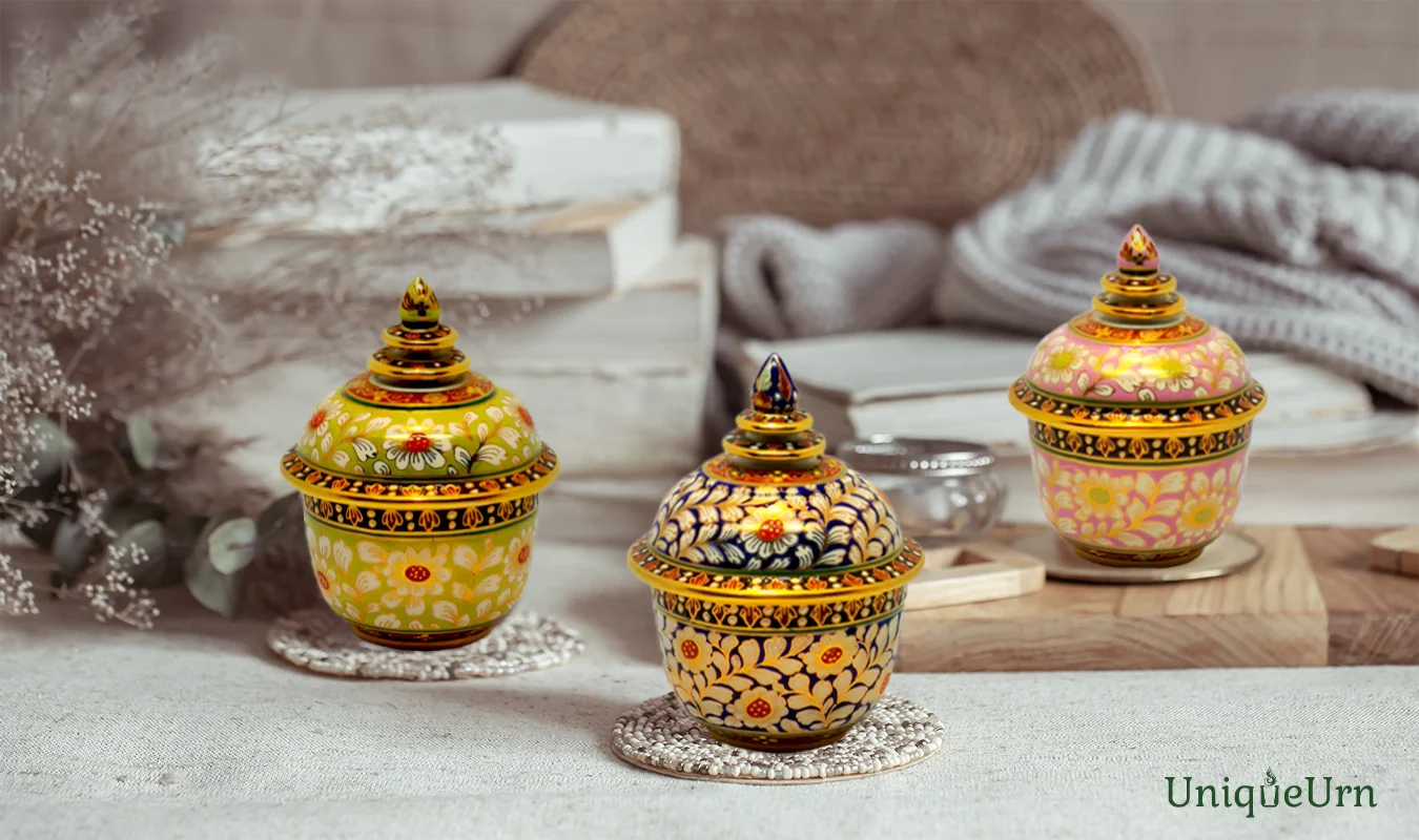Exquisite Bencharong art Thochan porcelain keepsake urn for ashes in pastel pink & green with gold Chakri pattern representing modern memorial design.