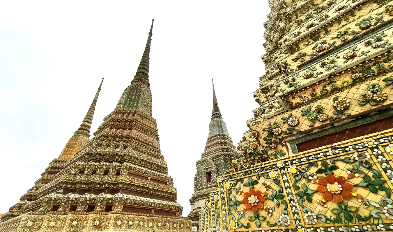 Meticulous porcelain floral ornamentation on the Great Stupas of Wat Pho represents a fusion of Thai and Chinese art styles - memorial arts as UniqueUrn.
