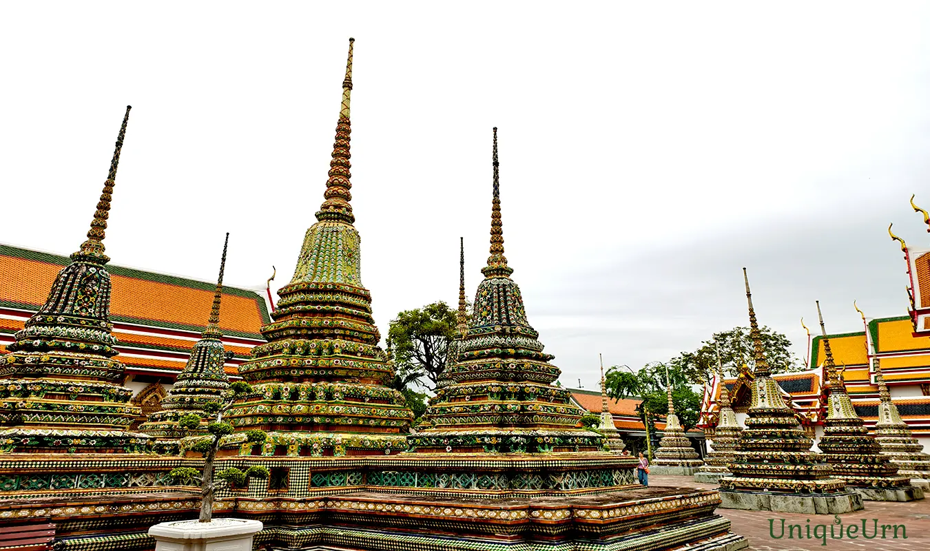 Meticulous porcelain floral ornamentation on the Great Stupas of Wat Pho represents a fusion of Thai and Chinese art styles - memorial arts as UniqueUrn.