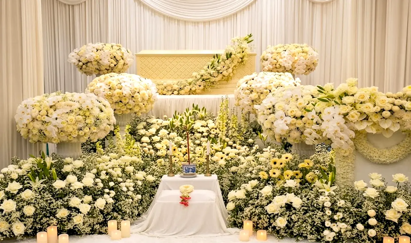 Warm and beautiful white and yellow flower decoration in front of the coffin at a funeral in Thailand.